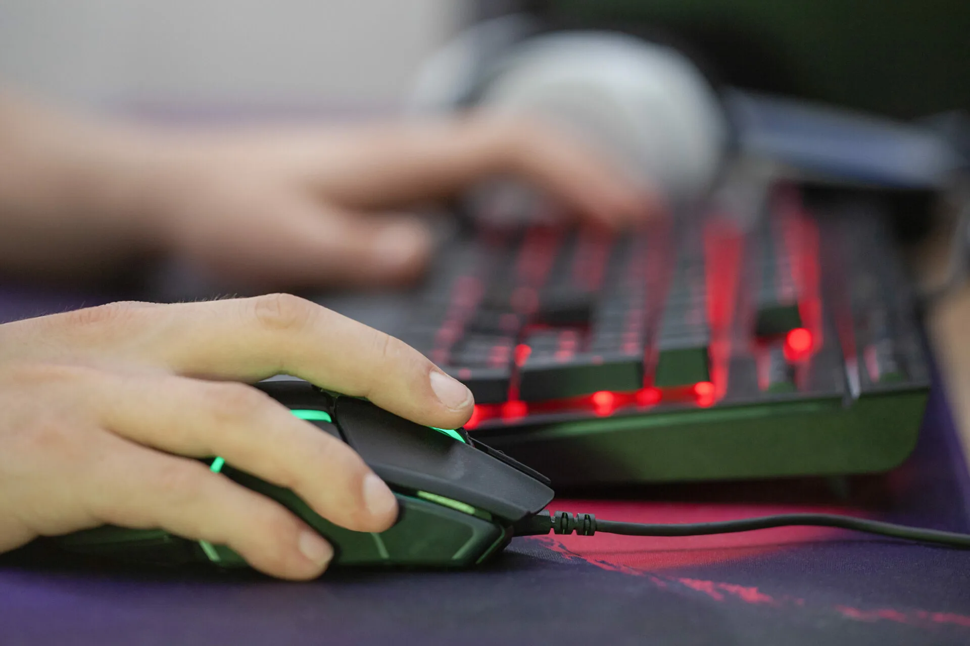 Ludoman spiller på gamertastatur med rødt lys